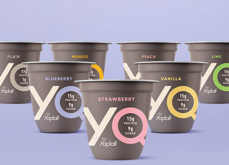 Assorted cups of YQ by Yoplait yogurt on a purple background
