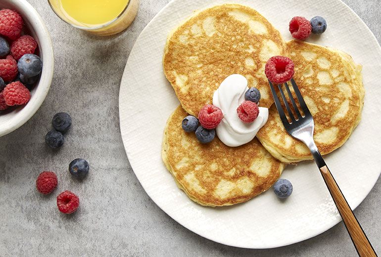a plate of grain free pancakes topped with fresh berries